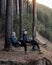 Men sitting in folding chairs on forest cliff