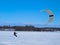 Men ski kiting on a frozen lake