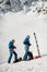 men skiers in ski suits and helmets putting on climbing harness