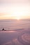 Men skiing in Alps. Magical fog around. Amazing sunset, snow all around, skiing resort beauty.Red