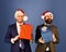 Men in smart suits and Santa hats on blue background.