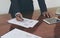 Men standing at desk and working writing document hand close up.