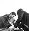 Men in suit or businessmen with screaming face compete in armwrestling on table on white background. Winner and defeated