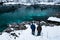 Men taking photos on beautiful emerald green lake zelenci in winter scenery, Kranjska Gora, Slovenia