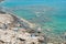 Men tourists enjoy fishing in sea blue water on rocky beach