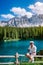 Men visit hte bleu lake in the dolomites Italy, Carezza lake Lago di Carezza, Karersee with Mount Latemar, Bolzano