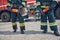 Men wearing protective uniform standing in front of fire modern machine