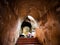 Men were Prostrating The Ancient Golden Bhddha Statue inside The Tunnel