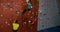 Men and woman climbing down the artificial wall at bouldering gym 4k