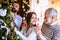 Men and woman family relatives indoors at home at Christmas, decorating tree.