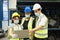 Men and woman work together, wear safety facemask and using laptop. Caucasian engineer men, black woman, Asian woman wear facemask