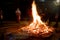 Men women families standing around giant blazing wood fire on lohri holi festival in india