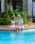 Men and women with hat drinking cocktails by the pool during vacation