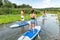 Men and women stand up paddleboarding
