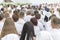 Men and women in white clothes prepare to receive water baptism