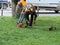 men workers with gas handheld string trimmers equipment during grass cutting team works. Poltava, Ukraine, May 12, 2019