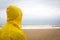 Men in yellow raincoat on the beach looking at storm.