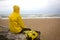 Men in yellow raincoat on the beach looking at storm.