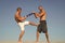 Men with yoga mat captured in motion blue sky background. Sportsman fighting. Practice fighting skills outdoor. Improve