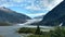 Mendenhall Glacier in Juneau Alaska. Large Glacier sliding into a lake with a waterfall beside it. Very popular tourist stop