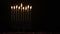 Menorah with burning candles in dark space for Hanukkah jewish holiday.