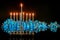 Menorah with burning silver candles for Hanukkah on black background with defocused lights