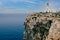 Menorca, Spain View of Cavalleria lighthouse with rocky cliff during a summer day with dramatic cloudy sunset in the balearic