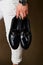 Mens fashion concept with mens hold black leather shoes in hand