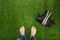 Mens feet resting on grass with lying boots