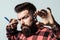 Mens haircut. Bearded style, fashion. Barber shop. Stylish barber with professional tools. Brutal hipster with beard, moustache