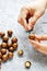 Mens hands cleaned with a special key macadamia nut on a gray concrete background, snack on a Keto diet