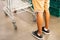 Mens legs and trolley. Male chooses products. Trolley at the grocery store. Interior of a supermarket, an empty shopping