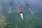 Mens quadruple rowing team on turquoise green lake