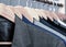 Mens suits in different colors hanging on hanger in a retail clothes store, close-up. Mens shirts, suit hanging on rack