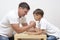 Mens Things. Father with His Little Son Having Arm-Wrestling Session Indoors