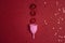 Menstrual cup with flowers and stars glitter on red background