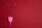 Menstrual cup with stars glitter on red background. Copy space for text