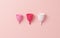 Menstrual cup in three different sizes isolated on a pink background. Zero waste, eco and reusable alternatives for period