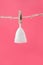 Menstrual cup white eco friendly reusable and silicone hanging on a clothesline isolated on a pink background