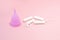 Menstrual cycle. Alternative means of hygiene and protection in critical days for women.Tampons or silicone menstrual cup on  pink