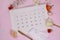 Menstrual cycle calendar on calendar background. Pink floral background with pads. Ovulation concept. Menstruation concept. Woman