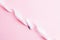 Menstrual tampon feminine hygiene. Pink ribbon with menstrual tampon on pink background. Menstruation feminine period