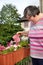 Mental disabled woman is watering some flowers