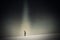 A mental health concept. Of a lonely figure walking in a dark minimal landscape. With a texture edit