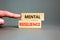 Mental resilience symbol. Concept word Mental resilience typed on wooden blocks. Beautiful grey table grey background. Doctor hand