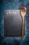 Menu background with chalkboard and cooking wooden spoon with heart, top view, place for text