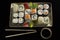 Menu of the Japanese restaurant. Several sushi lined on a plate with bamboo sticks and soy sauce.View of the rolls from above