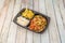 Menu tray of sauteed vegetable fajitas with rice with sweet corn and corn nachos in a home delivery container