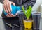 Menâ€™s hands pour water from a plastic bottle into a container with soil for growing plants. Plastic pot for seedlings with earth