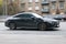 Mercedes-Benz CLA rushing on the city road. Black Mercedes CLA fastback sedan car moving on the street